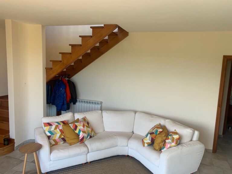 Living area with sofa and wooden staircase